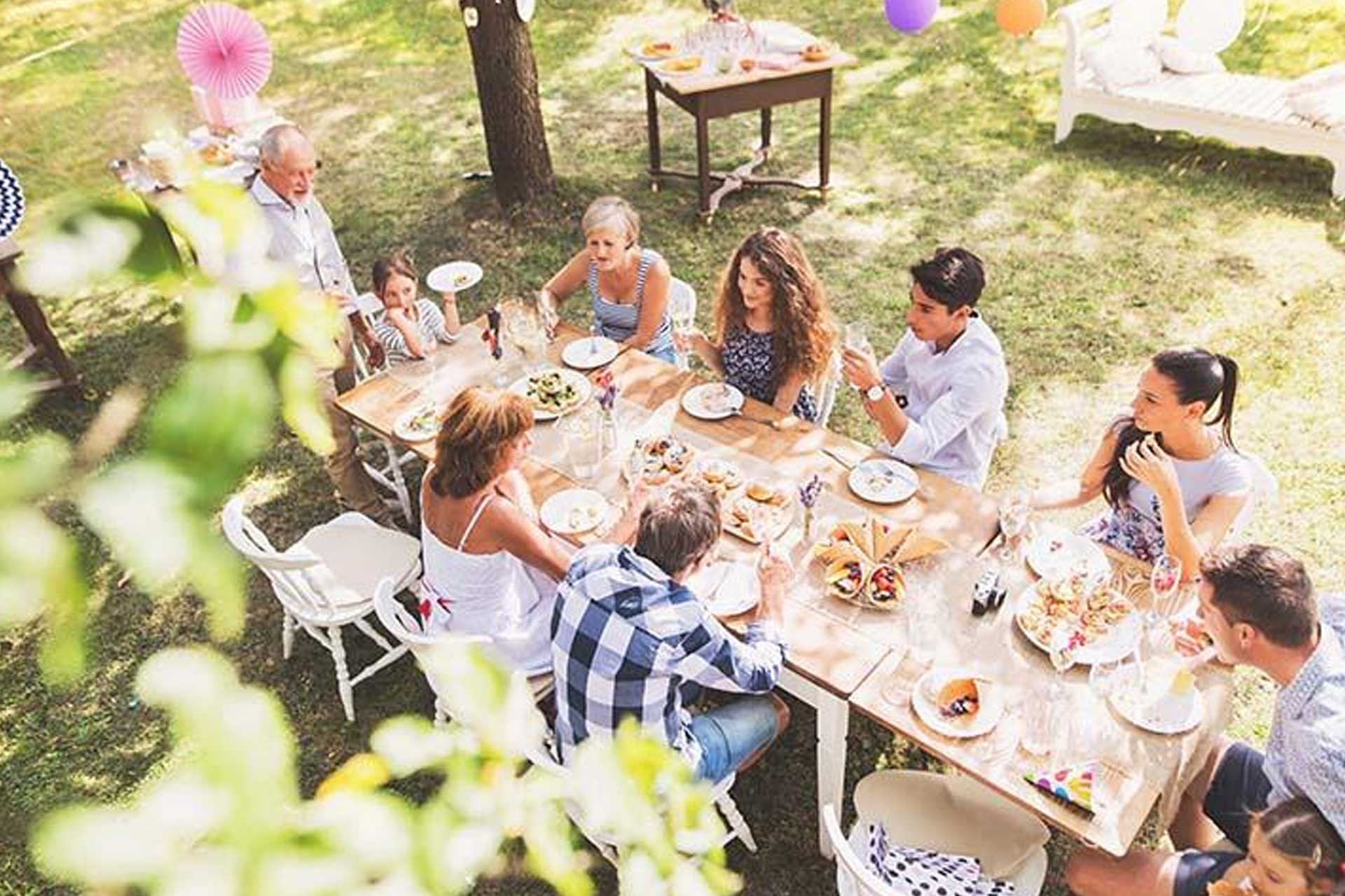 Family enjoying their backyard graduation party at a table in a mosquito- and tick-free environment, made possible by Pro Mosquito Solutions special event sprays.
