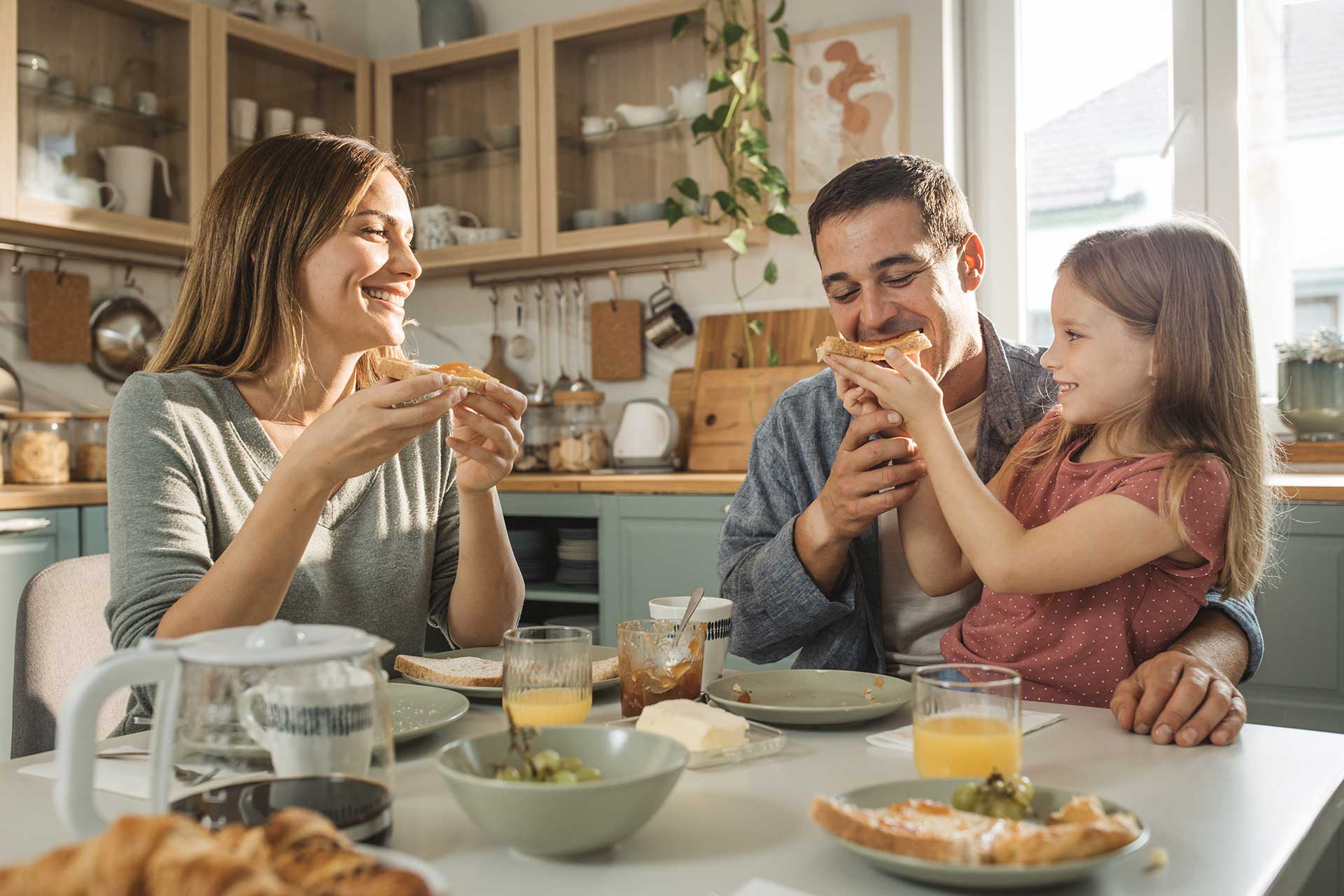 Happy family enjoying breakfast in a pest-free home, protected by Pro Mosquito Solutions pest control services in Rhode Island.