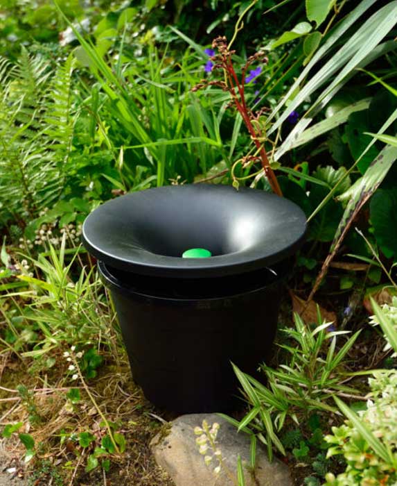In2Care mosquito trap discreetly placed in a flower bed, blending into the landscape while controlling mosquito populations in Rhode Island and Southeastern Massachusetts.