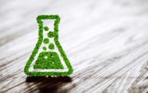 Green chemistry industry sign on a black wooden background, symbolizing eco-friendly practices and sustainable solutions related to organic pest control in Rhode Island.