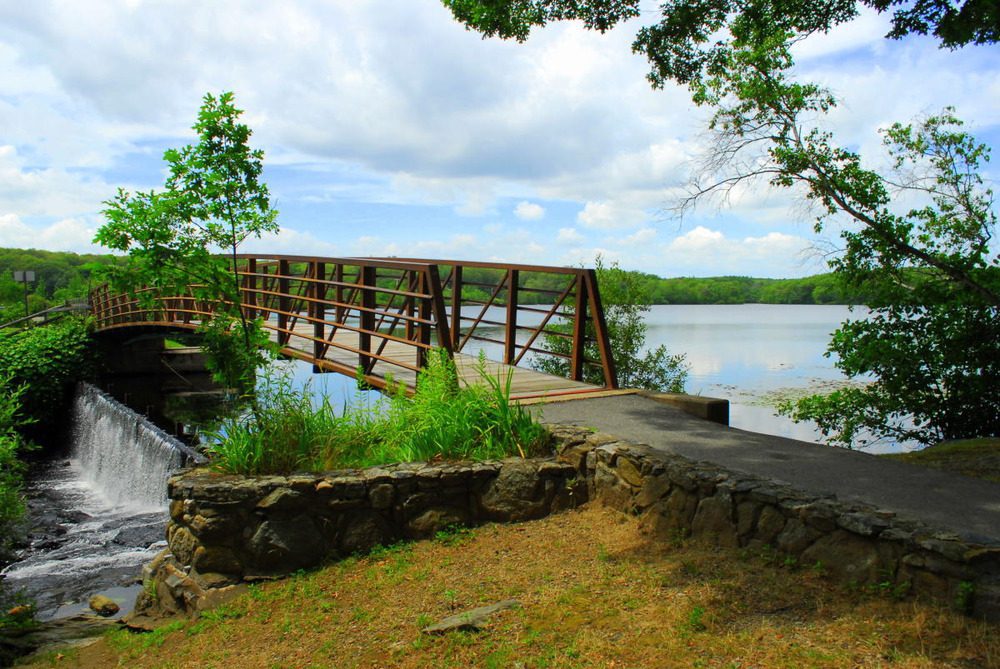 Scenic view of Governor Notte Park in North Providence, featuring a serene lake, lush greenery, walking paths, and picnic areas.