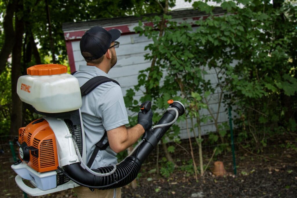 Pro Mosquito Solutions applying mosquito and tick barrier spray treatment at a home in Cranston, RI.