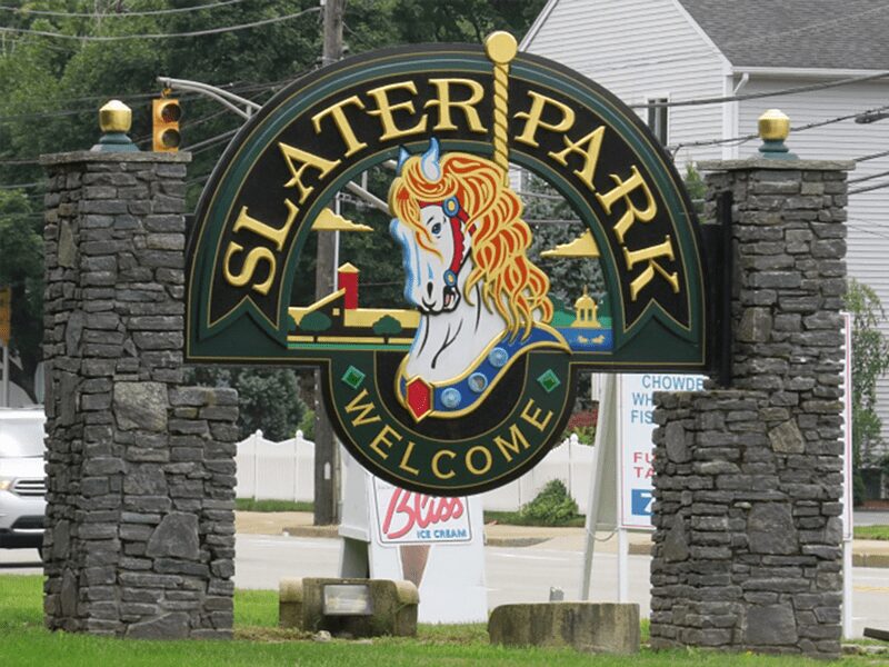 Slater Memorial Park in Pawtucket, RI, a scenic public park featuring walking paths, open green spaces, a pond, and historic landmarks.