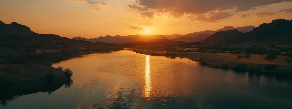 a breathtaking sunset casts a warm golden glow over a serene lake, with vibrant orange and pink hues reflecting on the glassy water surface.