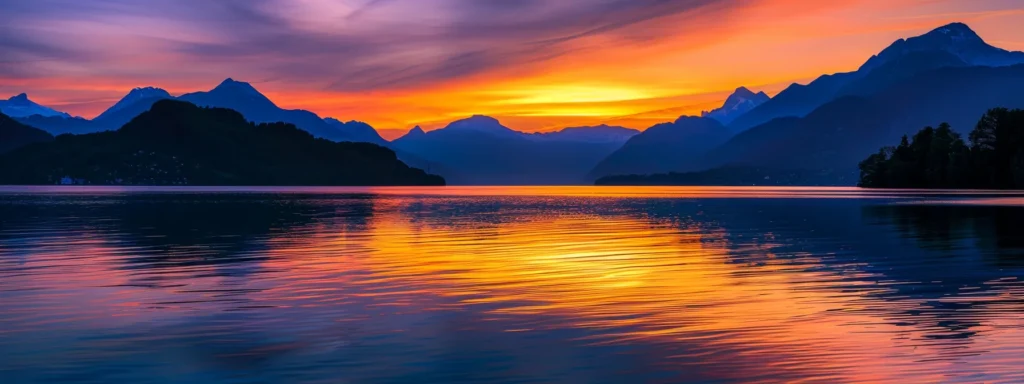 a vibrant sunset casts golden hues over a tranquil lake, reflecting the brilliant colors of the sky amidst silhouettes of towering mountains.